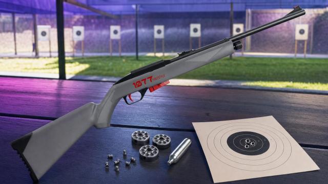 Crosman 1077 FreeStyle s rotačnými klipmi, CO₂ bombičkou a terčom na streleckom stole.