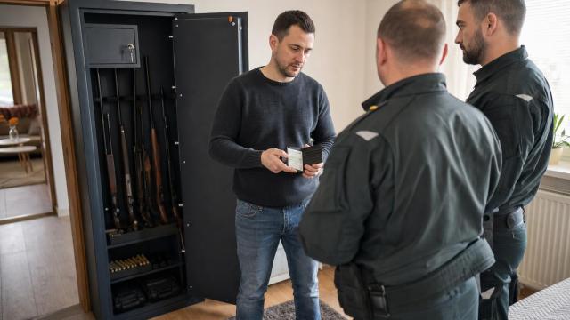 Policajná kontrola otvoreného trezora so zbraňami a strelivom v domácnosti.