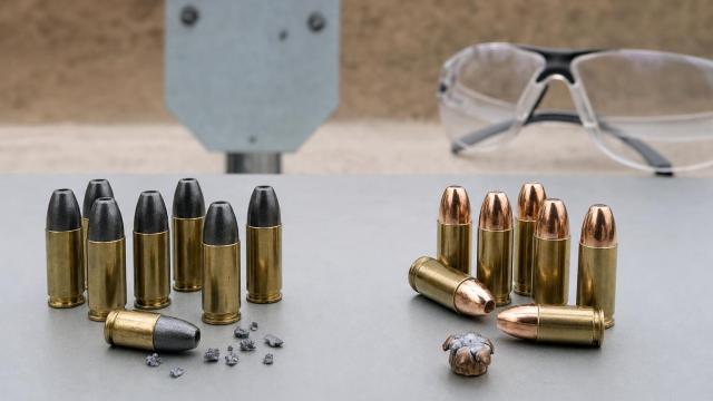 Trieštivé a FMJ náboje 9 mm Luger s fragmentmi pred oceľovým terčom.