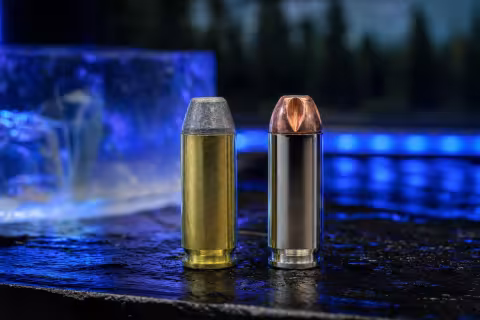 Náboje 10 mm Auto s hard-cast a drážkovanou monolitickou strelou položené vedľa seba.