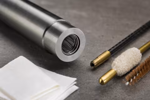 Detail komory hlavne .22 LR s viditeľným karbonovým prstencom a čistiacimi pomôckami.