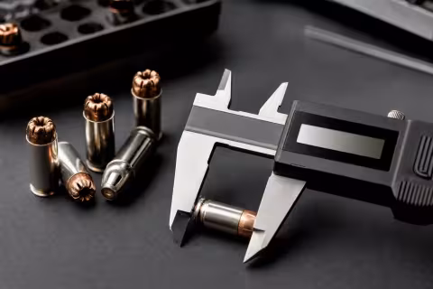 Meranie dĺžky náboja 9 mm posuvným meradlom pri kontrole zatlačenia strely.