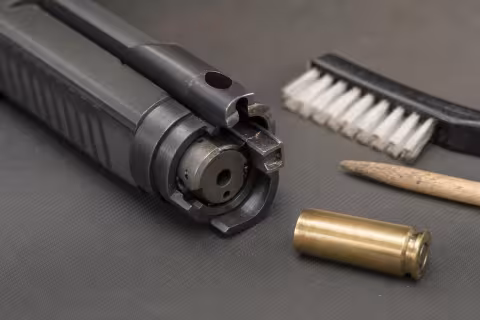 Detail znečisteného pazúra vyťahovača na rozobratom závere pištole.