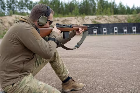 Strelec v kľaku stabilizuje pušku napnutým streleckým remeňom.