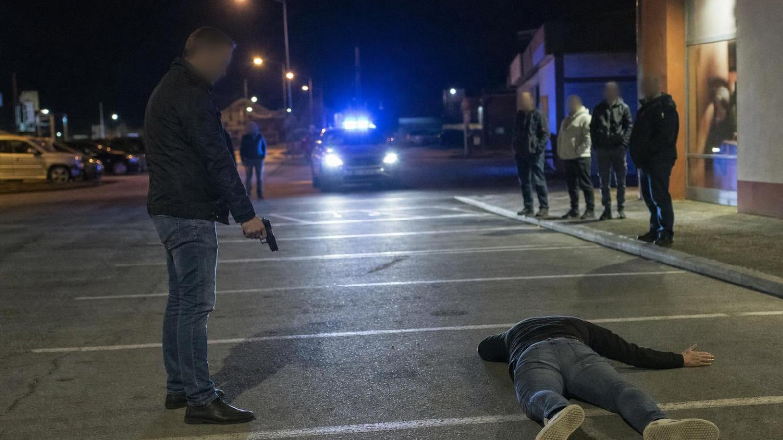 Ozbrojený civilista stráži ležiaceho podozrivého do príchodu policajnej hliadky.