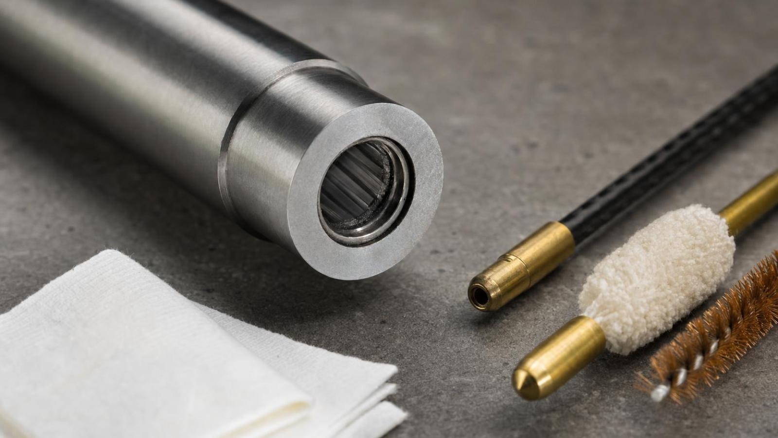 Detail komory hlavne .22 LR s viditeľným karbonovým prstencom a čistiacimi pomôckami.